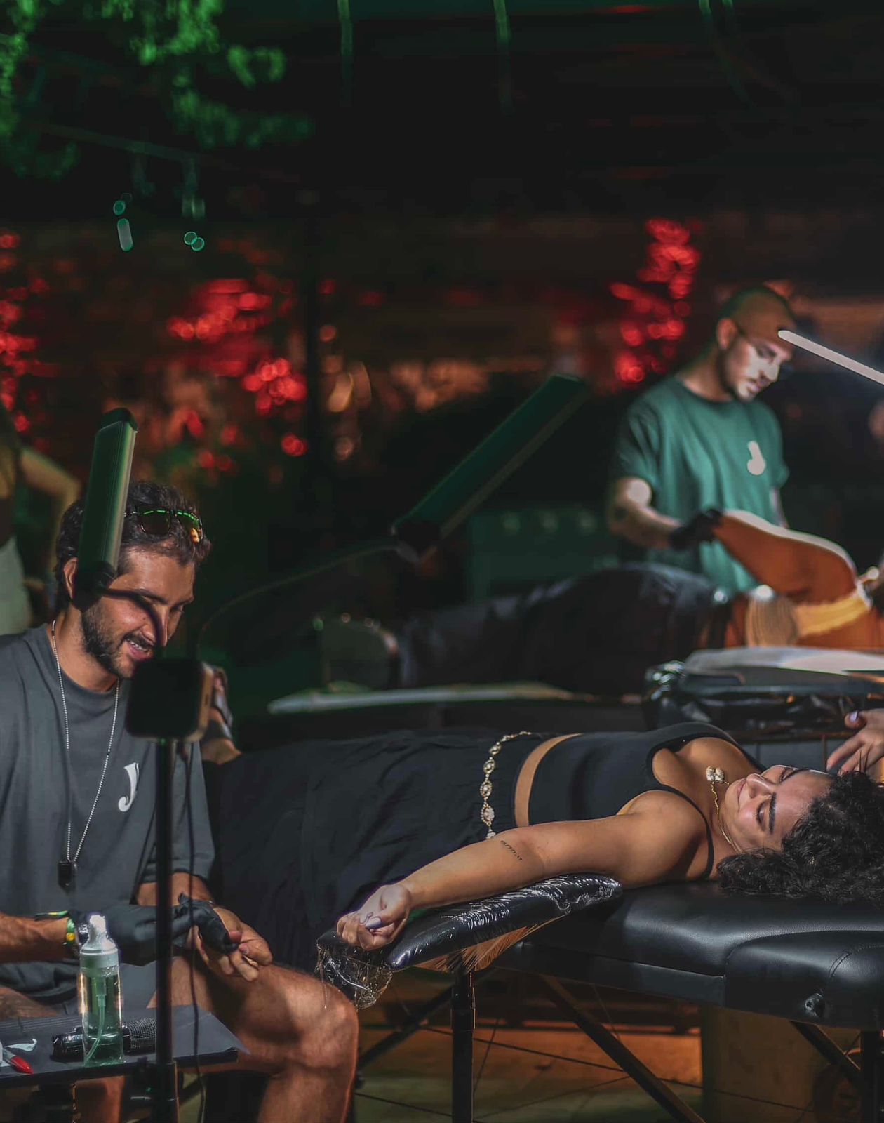 Aegis — outdoor live tattooing under festival lights