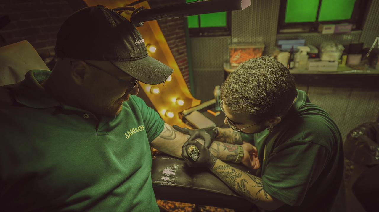 Reunion — tattooing in green-lit backroom