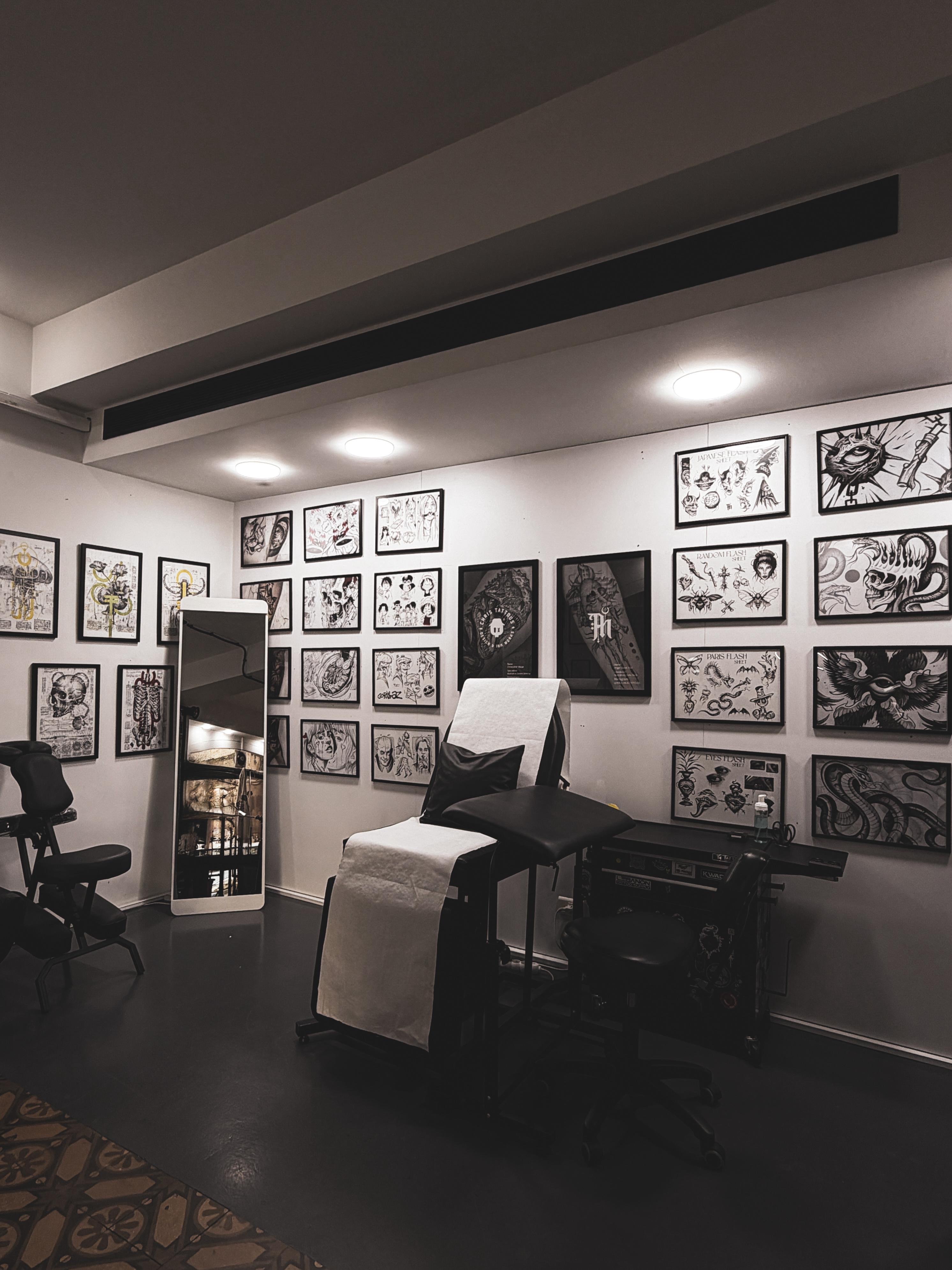 Wall of hand-painted flash art with tattoo chair