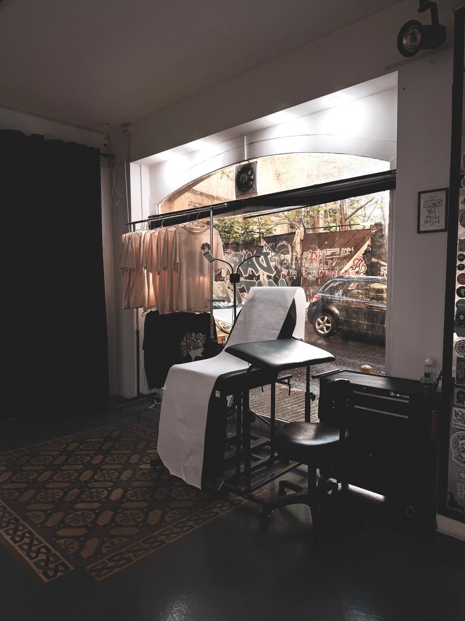Front room with merch rack and graffiti street view