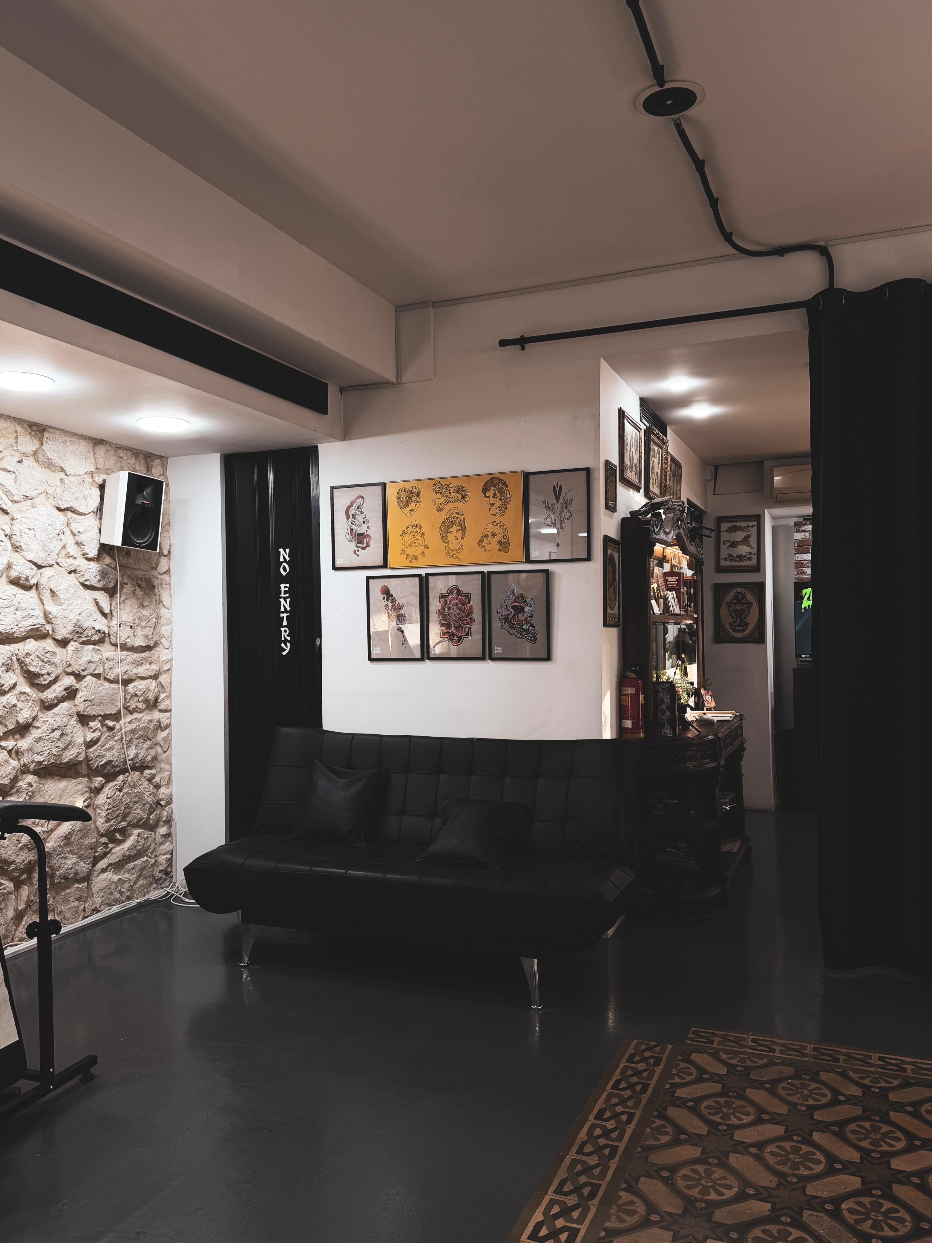 Lounge with black couch, framed flash, and No Entry door